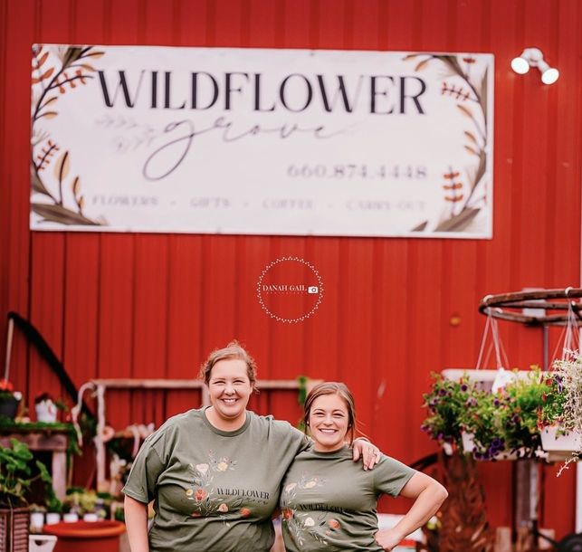 Alaina & Casey in front of Wildflower Grove The owners standing in front of Wildflower Grove sign
